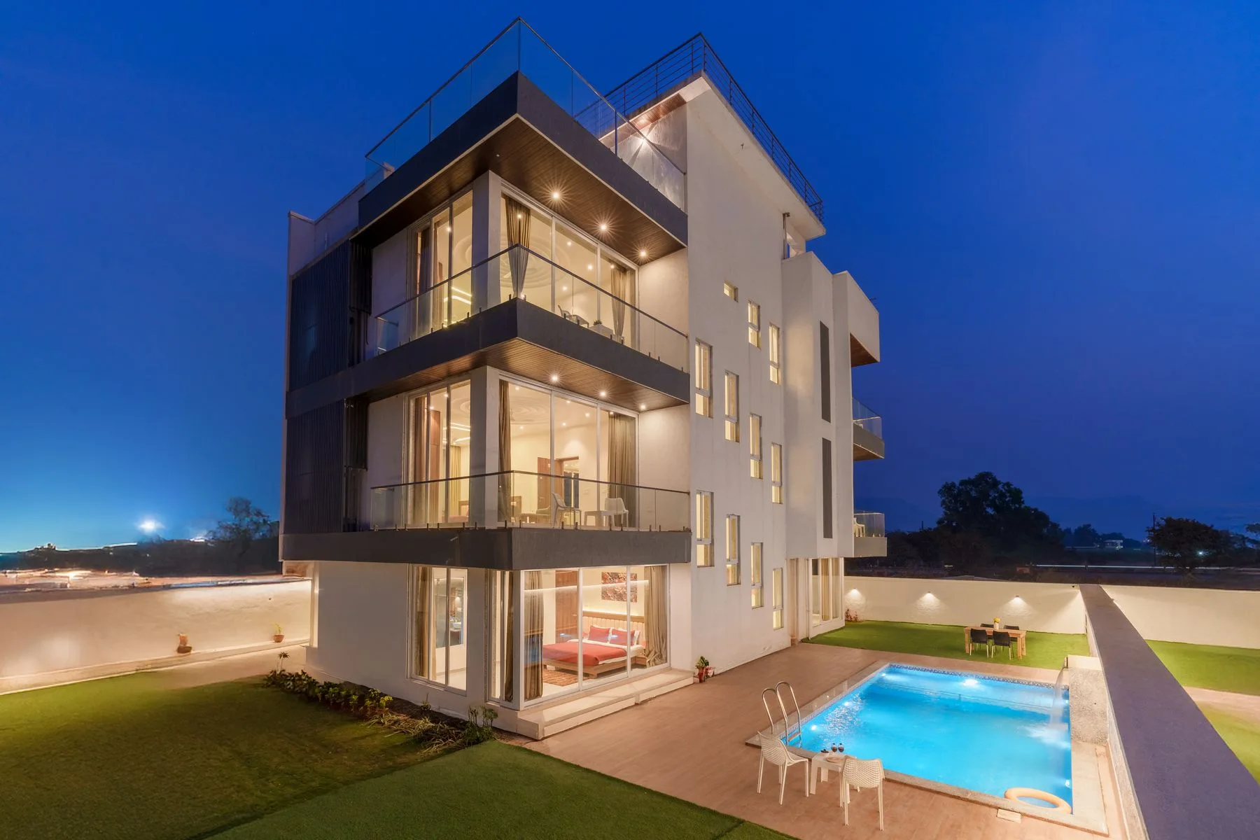 Modern illuminated villa and swimming pool at twilight