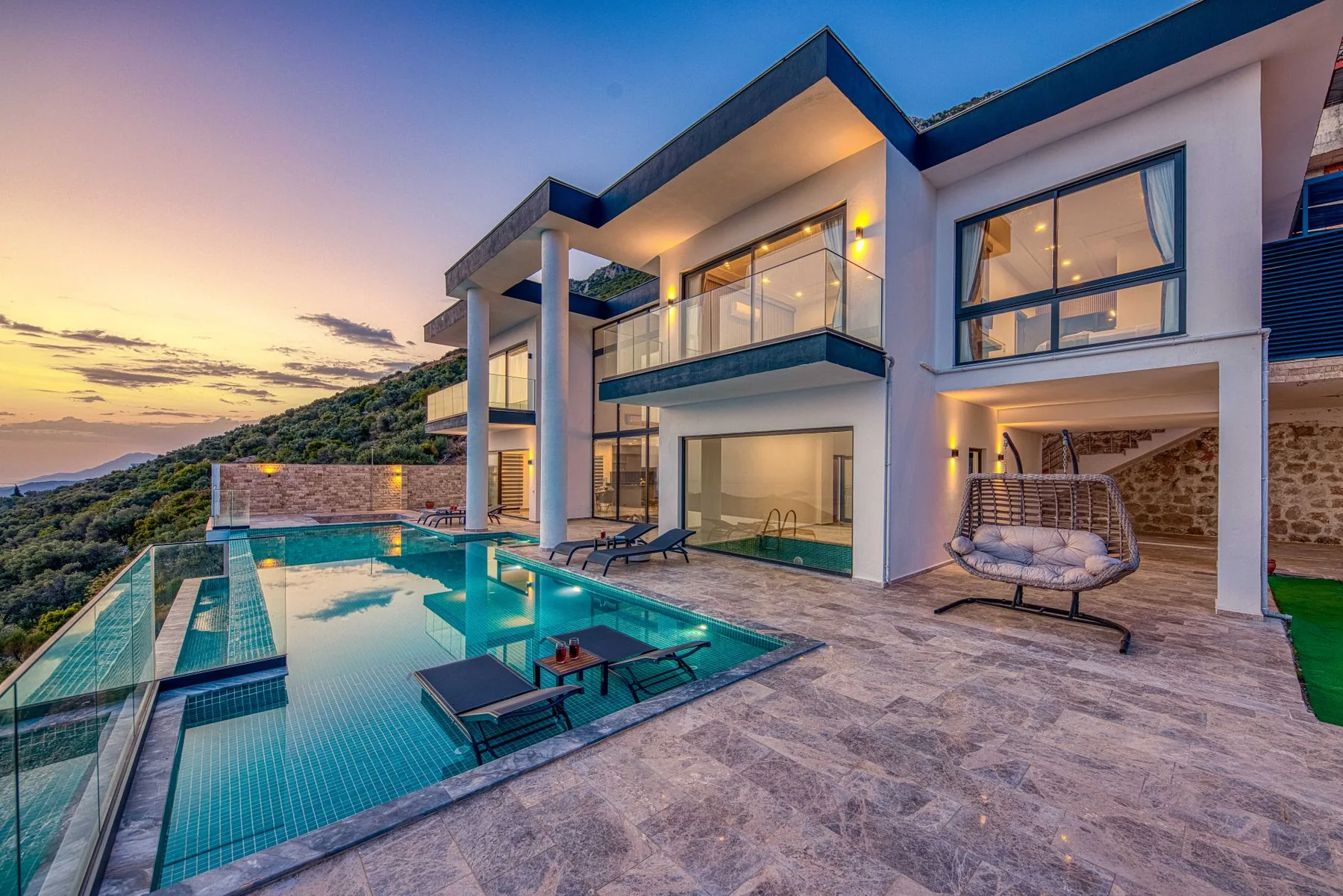 Contemporary villa overlooking an infinity pool at sunset